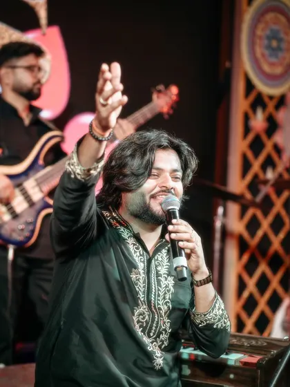 A candid shot of me at the harmonium, smiling as I interact with the audience. It's this connection that makes every live performance special.