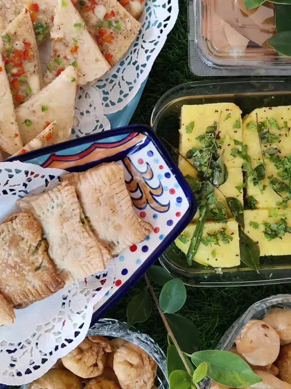 A delightful spread of homemade breakfast and snack items, including savoury puffs, fluffy dhokla, and other baked treats.