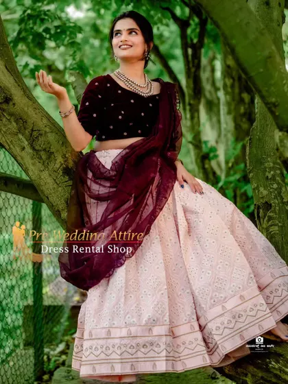 A chic and modern crop top and skirt set. The outfit pairs a simple off-white embroidered skirt with a rich maroon velvet blouse for a beautiful contrast.