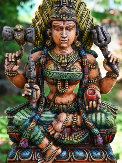 A close-up of the upper body of the Shri Devi (Amman) statue, highlighting her divine weapons and fierce expression.