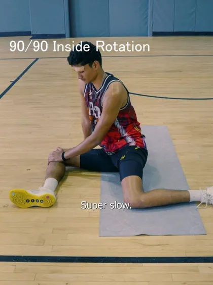 A close-up of an athlete performing the 90/90 inside rotation, a key exercise for strengthening the hip rotators.