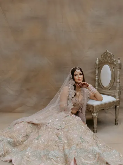A full-length view of the beautiful pastel lehenga. The soft makeup ensures the focus remains on the bride's natural beauty and her exquisite attire.