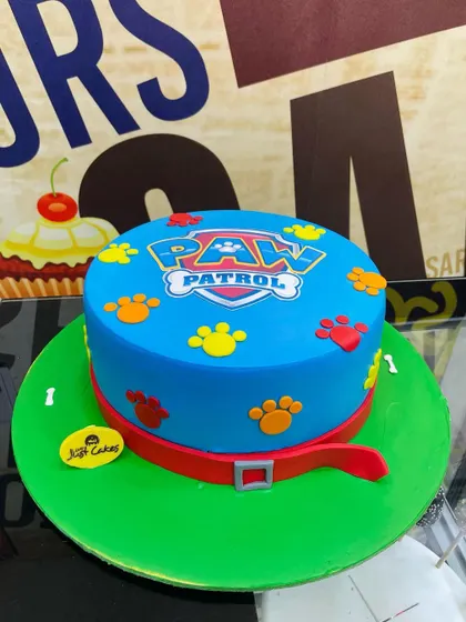 A simple yet classic 3kg Paw Patrol cake with the shield logo and colorful paw prints.