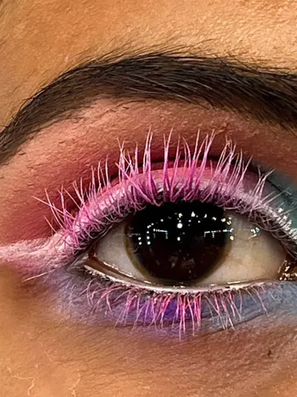 A macro shot of a creative eye makeup concept. I used custom-colored pink lashes and a soft blend of pastel eyeshadows with a sharp white wing to create a playful and artistic look.