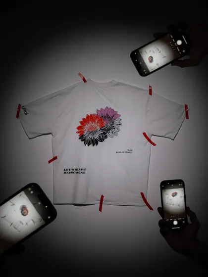 A creative concept for a t-shirt flat-lay. By surrounding the product with phones all taking its picture, the image playfully suggests that the design is "Insta-worthy" and trending.