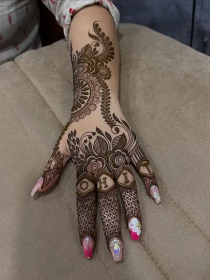 A personalized design with the name 'ROHI' creatively incorporated into the finger details. This is a wonderful way to make your mehndi unique.