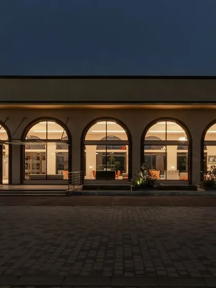 We designed the Brigade Valencia marketing office to be a welcoming space, inspired by the palaces of southern Spain. The series of arches glows with warm light at dusk, creating an inviting facade that moves beyond the typical cold corporate office.