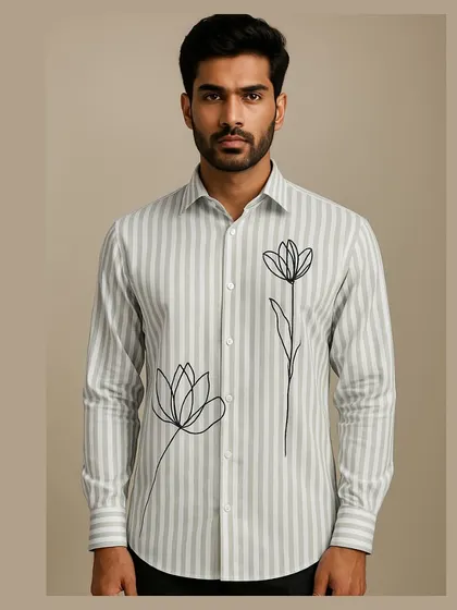 This shirt combines a classic light blue and white vertical stripe pattern with minimalist floral line art embroidery. It's a perfect example of how I blend traditional patterns with modern artistic touches for a sophisticated, breezy look.