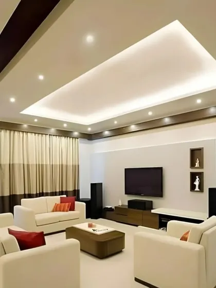 This living room design focuses on clean lines and subtle elegance. The recessed ceiling with cove lighting adds architectural interest, while the neutral color palette of the furniture creates a calm and spacious feel.