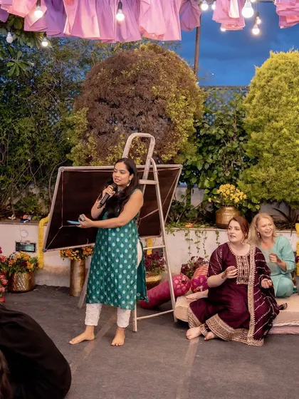 A family member speaks to the guests during an informal part of the Mehendi celebration, creating a warm and personal atmosphere.