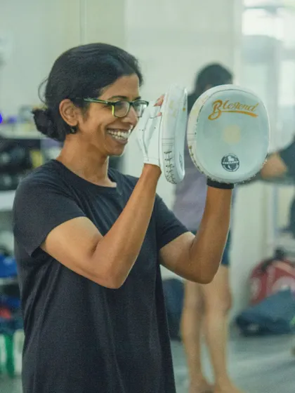 The joy of learning a new skill. A participant holds pads for the first time.