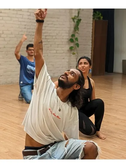 An instructor demonstrates a move with the classic open-arm pose, channeling the spirit of the King of Romance.