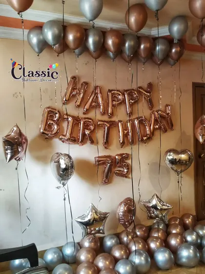 A simple yet elegant 75th birthday decoration for a home setting, featuring rose gold and silver foil and latex balloons.