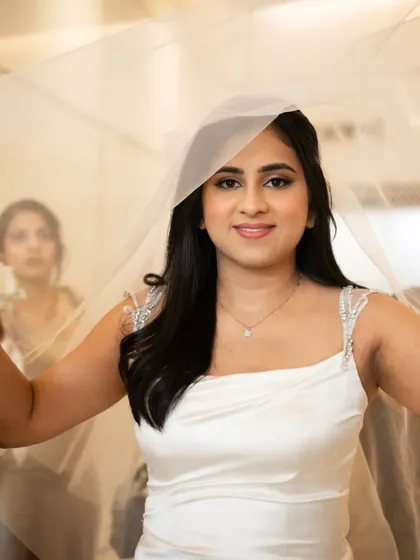 A lovely shot of the bride holding her veil. Her makeup is clean and fresh, letting her natural beauty be the star.