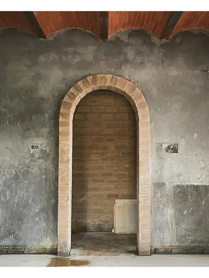 An arched doorway at the 'VKR' site, showcasing the beauty of raw, unfinished materials.