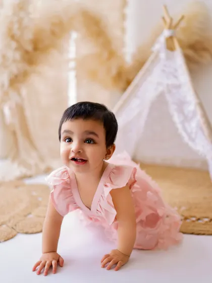 On the move! Capturing babies as they start to crawl and explore is a key part of my milestone sessions. This little one is dressed in a lovely pink outfit.