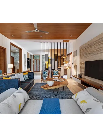 An alternate view of the formal living room, showing the wooden-clad ceiling and bamboo lights that add a layer of warmth and coziness.