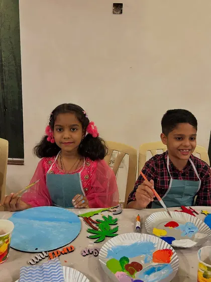 Two young artists focused on their project. At this party, kids got to paint on round wooden plaques, mixing colors and creating their own unique designs.