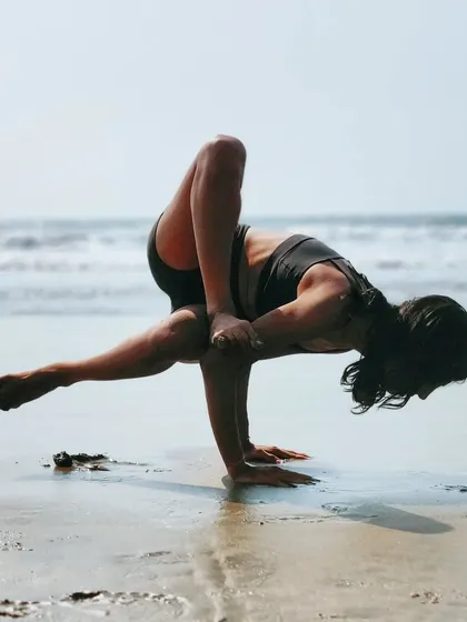 A grasshopper among the crabs. Playing with a fun arm balance, Parsva Bhuja Dandasana, on the wet sand.