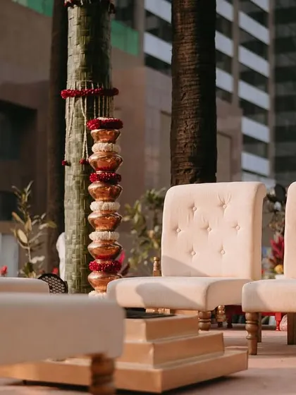 The seating for the couple and their parents, featuring elegant cream-colored chairs and traditional stacked copper pots.