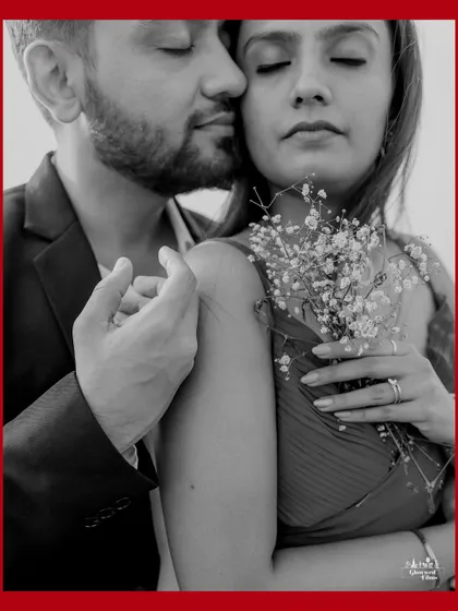 A tender black and white close-up, where the couple's eyes are closed in a moment of quiet connection. The delicate baby's breath flowers add a touch of softness and romance to this intimate portrait.