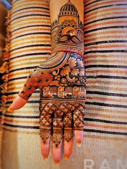 The same royal design, but this time showing the full hand with detailed patterns on the fingers. The combination of bold figures and fine lines creates a stunning effect.