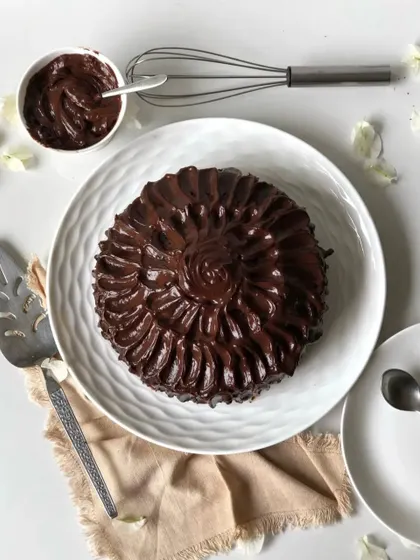 An overhead view of my dense chocolate cake, completely covered in rich, swirling chocolate ganache. It's as delicious as it looks.