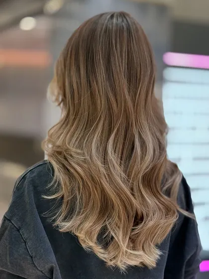 A beautiful ash blonde balayage that is perfect for someone wanting to lighten their look without a high-maintenance commitment. The color is modern and chic.