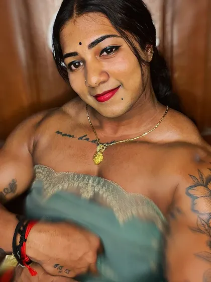 Beauty with the Beast. This close-up in a simple, elegant top shows the details of my 'mom dad' tattoo and the powerful definition of my chest and shoulder muscles.