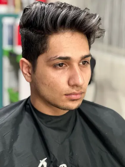 Crafting it silver. This men's style features silver highlights on dark hair, creating a cool contrast and adding texture to the haircut.