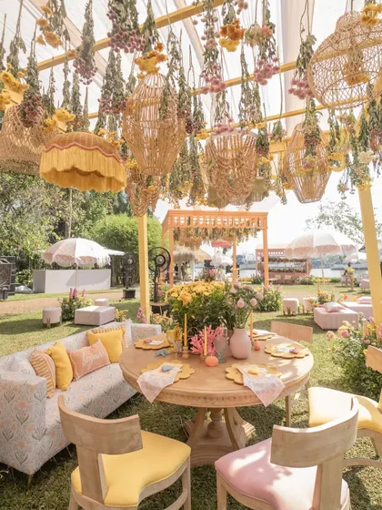 A comfortable lounge area under a canopy of hanging flowers and wicker lanterns, perfect for a relaxed brunch conversation.