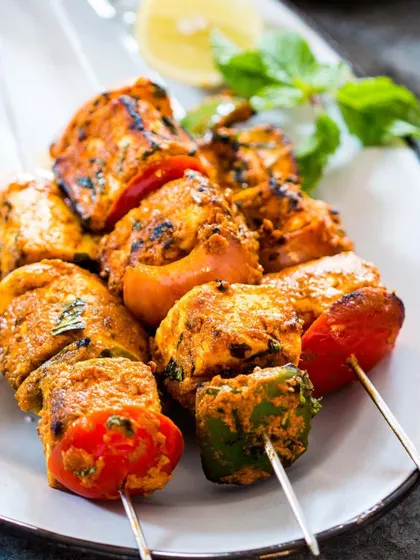 A close up of my Paneer Tikka skewers, featuring succulent pieces of marinated paneer grilled with colourful bell peppers and tomatoes.