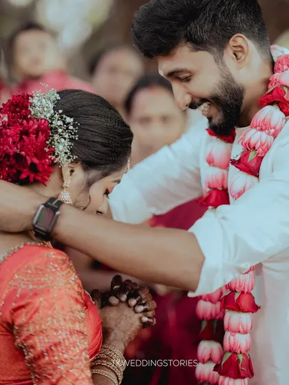 A close-up of a groom placing the sacred thaali (mangalsutra) around the bride's neck during a Kerala wedding ceremony. A pivotal and emotional moment.