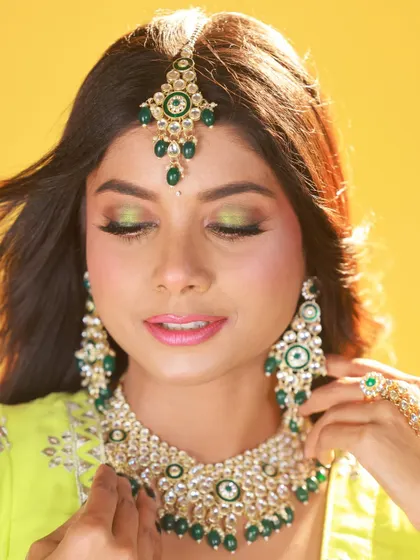 A close-up beauty shot focusing on the model's makeup. The soft lighting is ideal for highlighting the details of the eye shadow and the intricate jewellery.