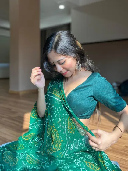 A gentle, downward glance, capturing the intricate details of the bandhani saree.