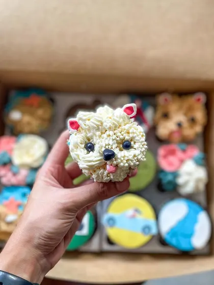 An adorable dog face cupcake, piped with textured buttercream to look like fur.