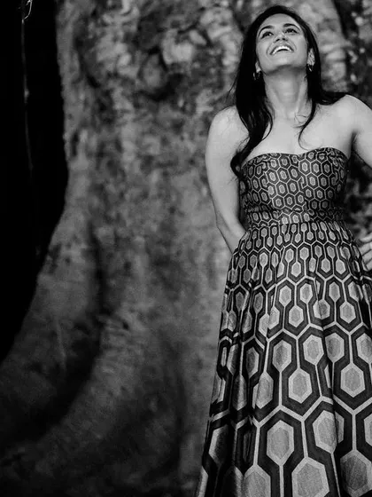 A candid black and white shot of a woman's joyful reaction during a surprise proposal.