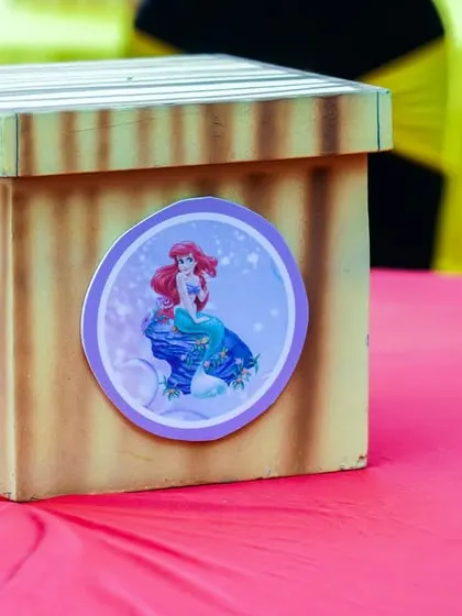 A themed centerpiece box for the Mermaids vs. Pirates party, featuring both Ariel and a pirate character.
