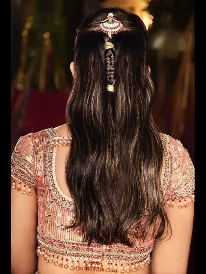 A close-up on the back of the Tarun Tahiliani blouse and the intricate hair accessory. The detailed beadwork and elegant hairstyle are key components of this look.