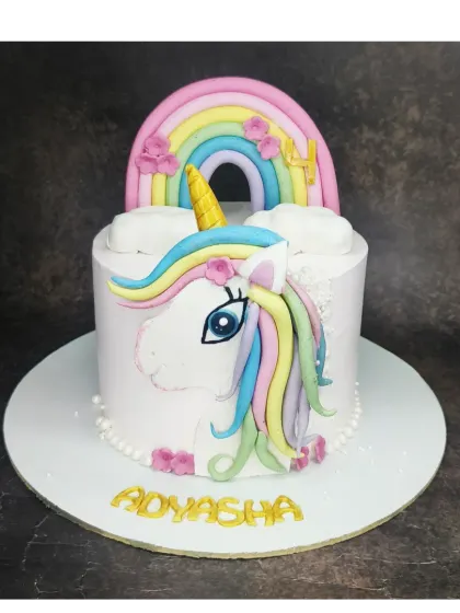 A unicorn face cake with a handmade fondant horn and rainbow mane. This is an eggless black forest cake filled with a homemade fresh cherry compote.