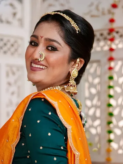 Her smile lights up the frame. The makeup is designed to look radiant and feel comfortable, allowing the bride's personality to shine through.