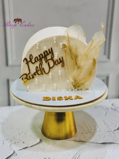 A modern cake top-forward design, this creation is adorned with a delicate rice paper sail for a touch of ethereal beauty.