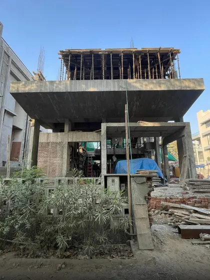 **Dwelling in Splits, Ahmedabad:** A view from the street shows the bold, cantilevered forms of the concrete slabs. The design preserves privacy while hinting at the interconnected, multi-level spaces within.
