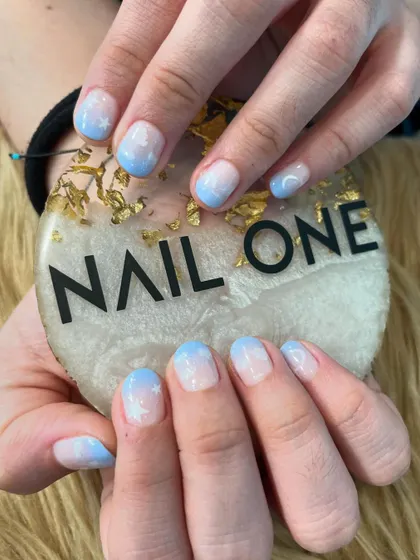 A closer look at the sky-inspired nail art. This design on short, rounded nails is perfect for a subtle yet imaginative look.