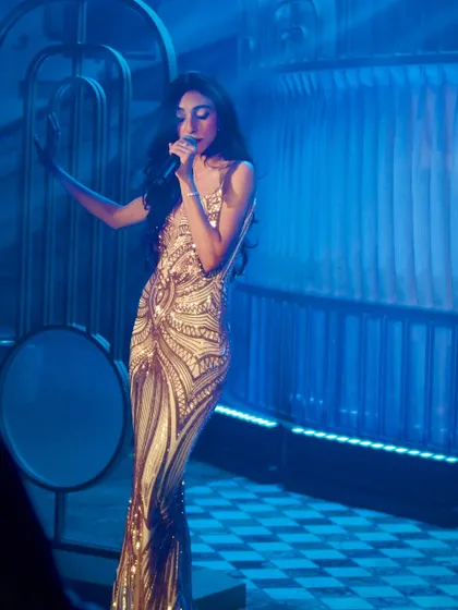 A full-length shot of my performance in a stunning gold gown, showing the glamour and stage presence we bring to premier events.