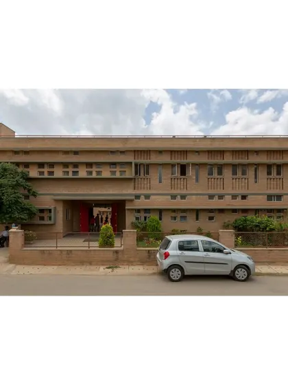The main entrance of Buddhi School, showcasing the warm texture of compressed stabilised earth block (CSEB) masonry. The entire school is designed to be fully accessible and was built on existing rock to minimize foundation costs and preserve the natural landscape.