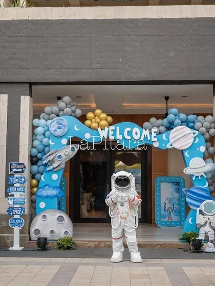 The full entrance setup for the space party, featuring an astronaut mascot, multiple signs, and impressive balloon arches.