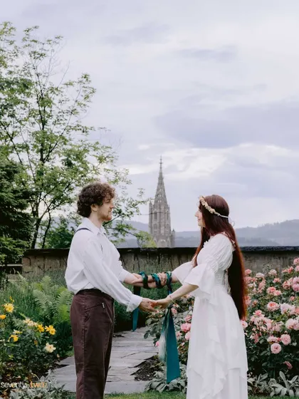 An ancient Celtic hand-fasting ritual performed in a beautiful garden in Bern, Switzerland. Servane and Justin bound their hands and hearts in a promise of forever, with a historic cathedral spire in the distance.