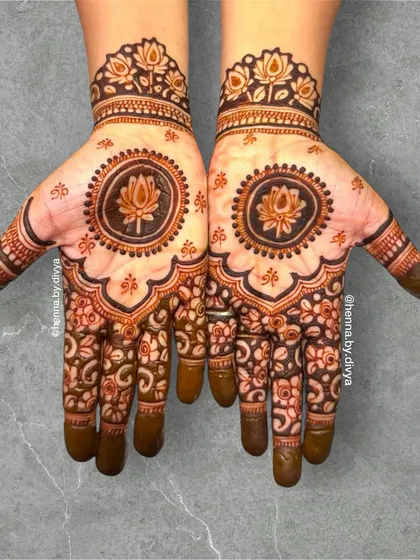 A beautiful lotus mandala design. The central lotus is surrounded by intricate floral patterns that cover the palm, creating a full and symmetrical look.