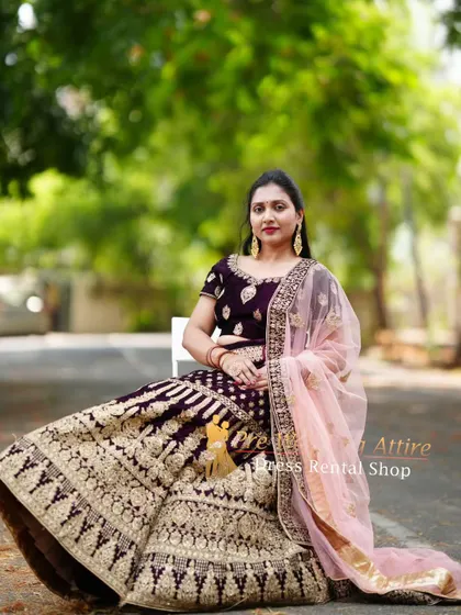 A seated portrait showcasing the beautiful flare and detailed embroidery of the velvet lehenga skirt.